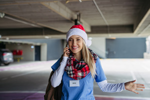 care worker in scrubs and a Christmas hat